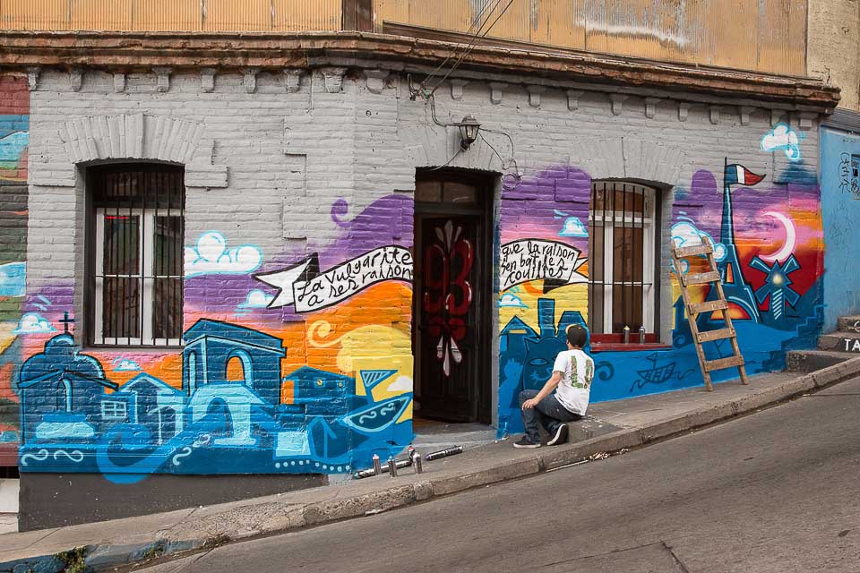 artist working on commissioned street art in Valparaíso, Chile